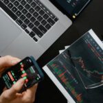Trading Tools - Hands Holding a Smartphone with Data on Screen
